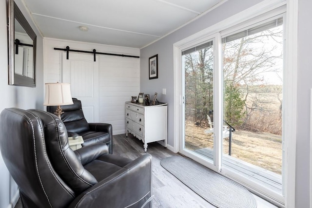 1 Ladd Ave, Wareham, MA 02571 - living area with a barn door, wood finished floors, crown molding, and baseboards