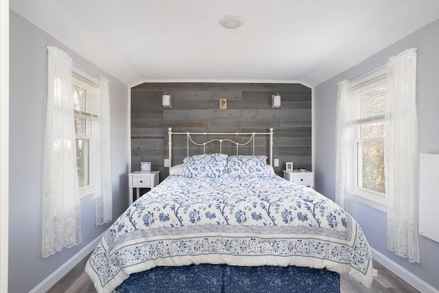 1 Ladd Ave, Wareham, MA 02571 - bedroom with multiple windows, wood walls, baseboards, wood finished floors, and an accent wall