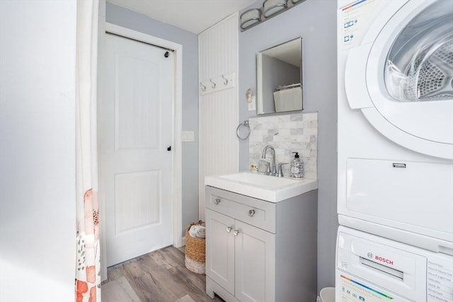 1 Ladd Ave, Wareham, MA 02571 - bathroom with stacked washer / drying machine, vanity, wood finished floors, and backsplash