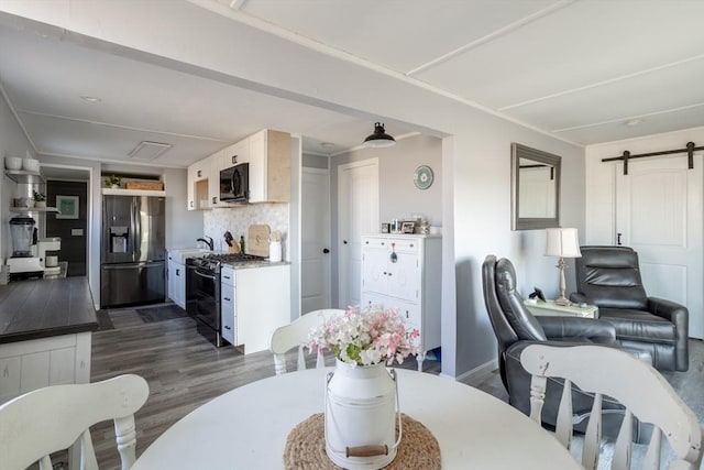 1 Ladd Ave, Wareham, MA 02571 - dining room with dark wood-style flooring, a barn door, and baseboards