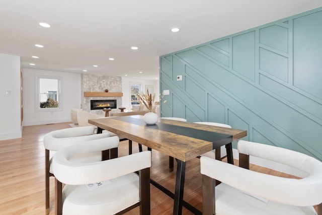 dining space featuring a large fireplace and light wood-type flooring