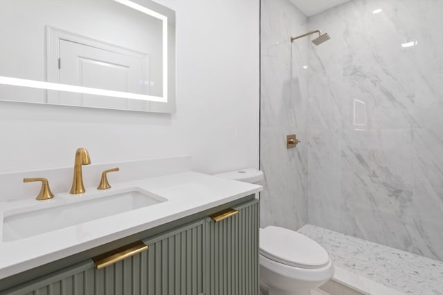 bathroom featuring vanity, toilet, and tiled shower