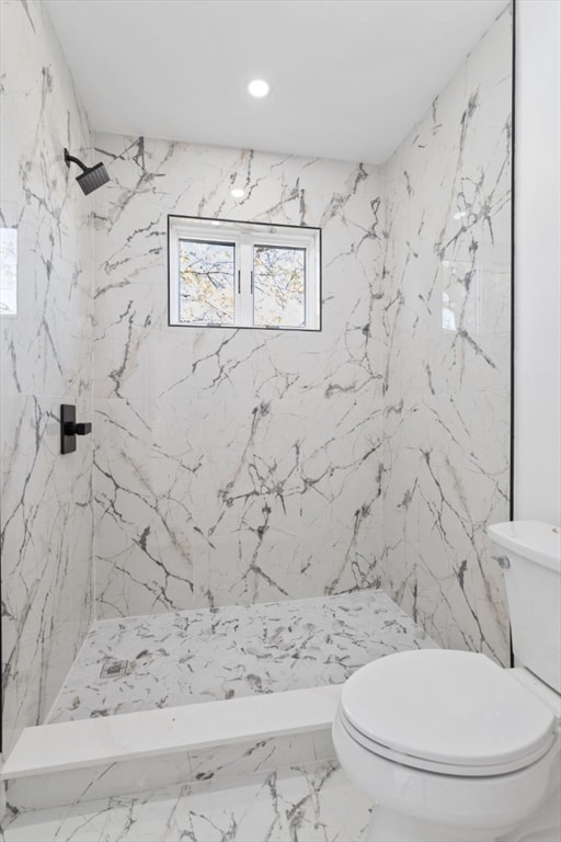 bathroom featuring toilet and a tile shower