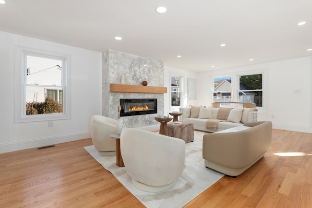 living room with a large fireplace and light wood-type flooring