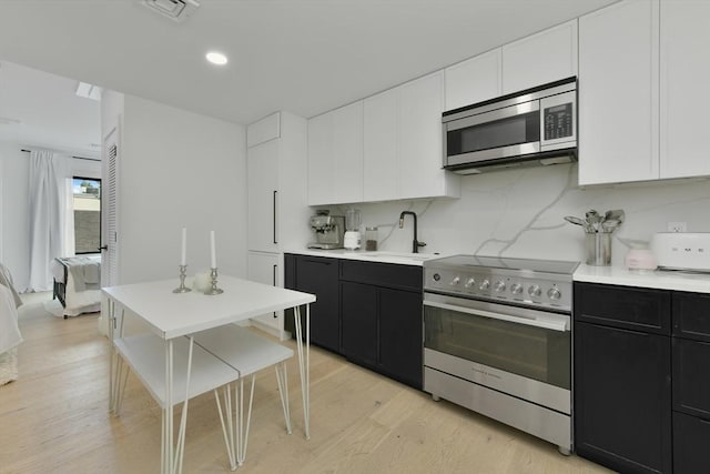 50 Leo M Birmingham Pkwy Unit 405, Boston, MA 02135 - kitchen featuring appliances with stainless steel finishes, a sink, dark cabinetry, light countertops, and recessed lighting