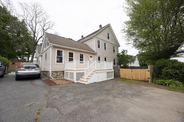 27 Union St Unit 27, Natick, MA 01760 - view of front facade with a deck, roof with shingles, a chimney, and stairs