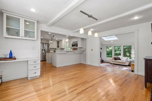 11 Laurel Dr, Scituate, MA 02066 - kitchen with stainless steel appliances, open floor plan, a skylight, a peninsula, and beam ceiling
