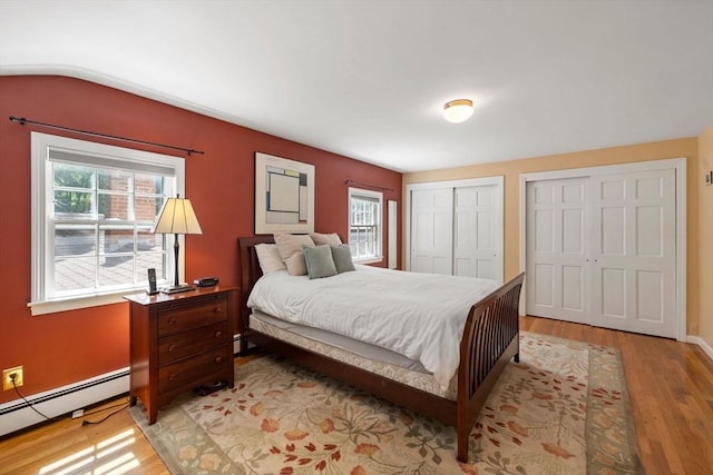 11 Laurel Dr, Scituate, MA 02066 - bedroom with a baseboard heating unit, light wood-style floors, multiple closets, and vaulted ceiling