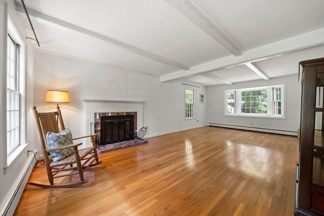 11 Laurel Dr, Scituate, MA 02066 - living room featuring baseboard heating, a baseboard heating unit, light wood finished floors, beam ceiling, and a brick fireplace