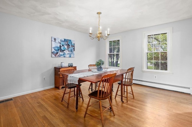 dining space with light wood-style floors, a chandelier, a baseboard radiator, and baseboards