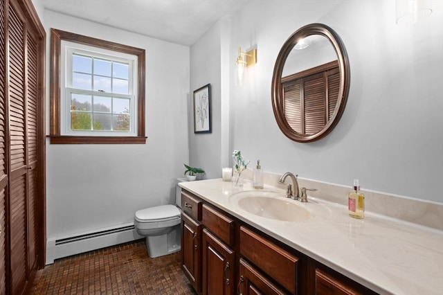 bathroom with baseboard heating, toilet, vanity, and a closet