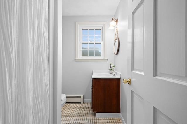 bathroom featuring baseboard heating, vanity, toilet, and baseboards