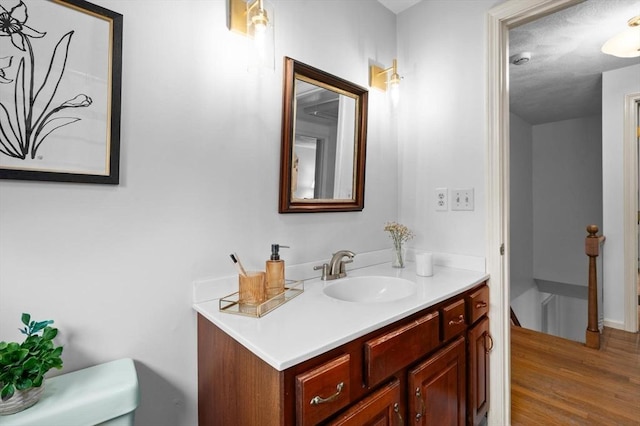 bathroom featuring wood finished floors, vanity, and baseboards