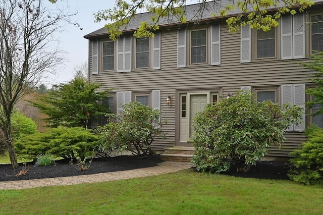 colonial inspired home with a front lawn and entry steps
