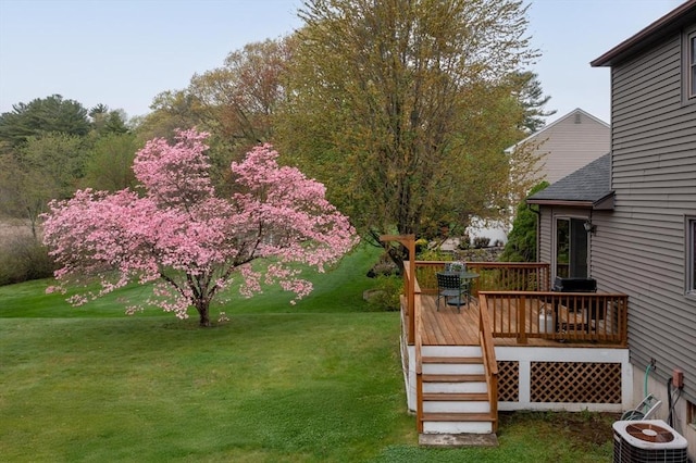 view of grassy yard featuring a wooden deck and central AC