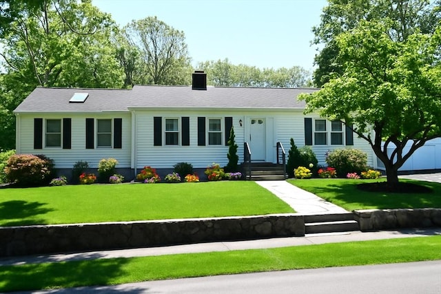 single story home featuring a chimney and a front lawn