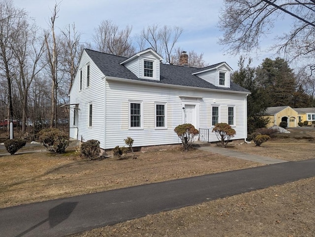 cape cod home with roof with shingles and a chimney