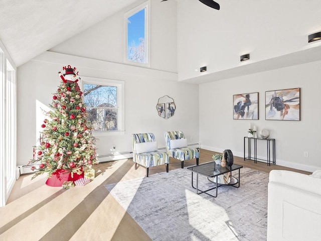 living room with baseboard heating, high vaulted ceiling, and hardwood / wood-style flooring