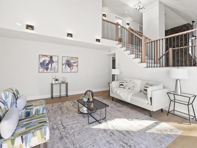 living room featuring a chandelier, a high ceiling, and hardwood / wood-style flooring