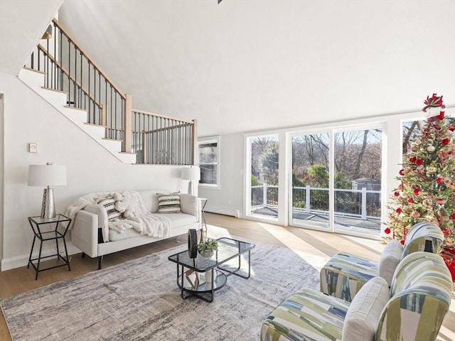 living room featuring baseboard heating, a wealth of natural light, and hardwood / wood-style flooring