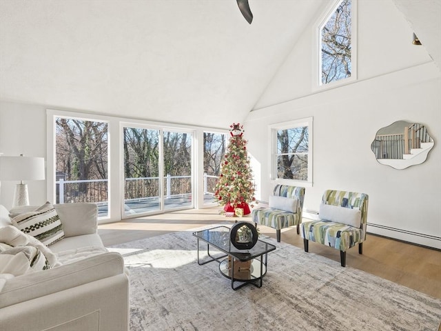 living room featuring hardwood / wood-style flooring, ceiling fan, baseboard heating, and high vaulted ceiling