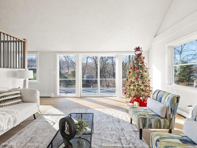 living room with baseboard heating, lofted ceiling, and hardwood / wood-style flooring