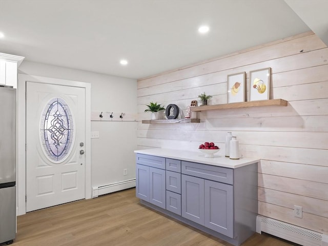 washroom with light hardwood / wood-style flooring and a baseboard heating unit