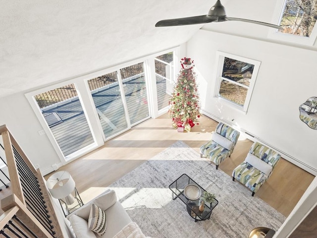 living room with light wood-type flooring, vaulted ceiling, and ceiling fan