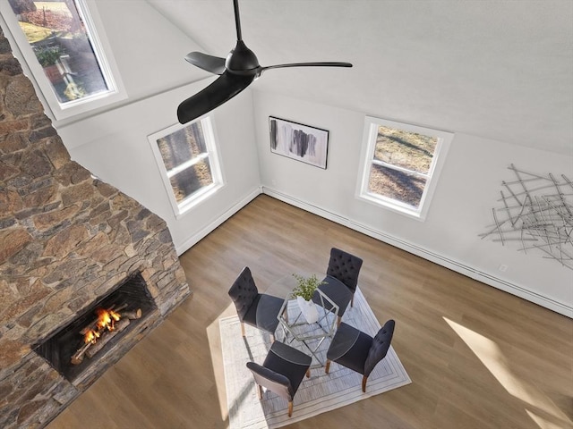 living room with ceiling fan, a fireplace, wood-type flooring, and lofted ceiling