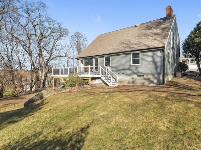 rear view of house featuring a deck and a lawn