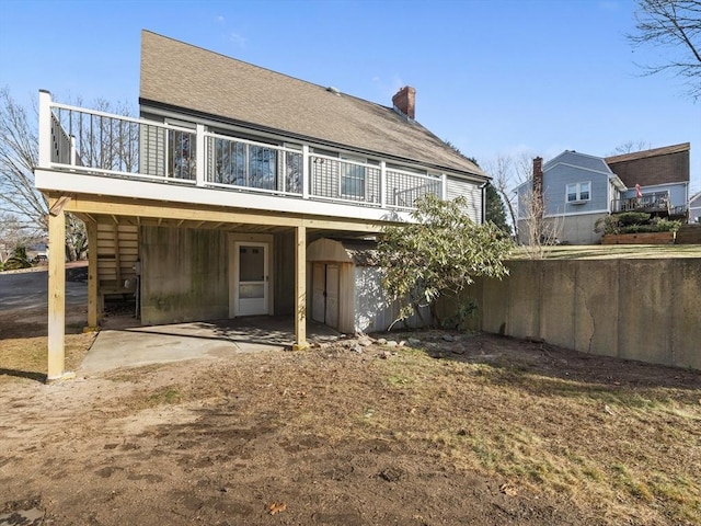 rear view of property with a wooden deck and a patio