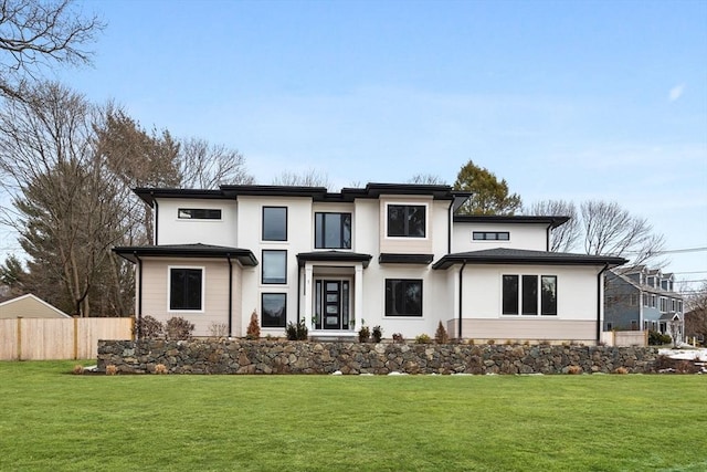 prairie-style house with fence, a front lawn, and stucco siding