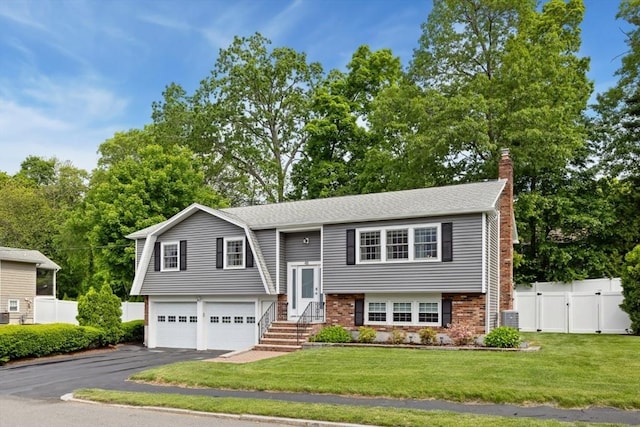 48 W Park Dr, Wakefield, MA 01880 - raised ranch with a chimney, a garage, asphalt driveway, a gate, and cooling unit