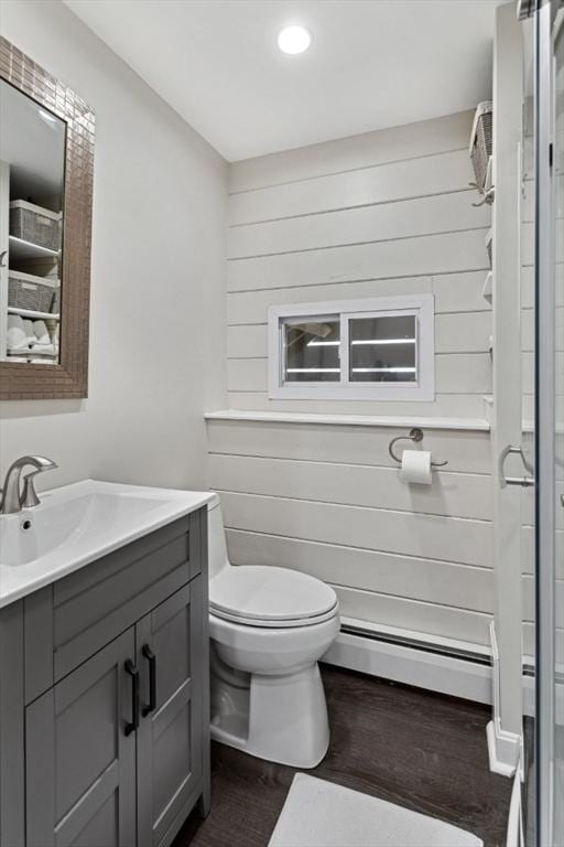 48 W Park Dr, Wakefield, MA 01880 - bathroom with baseboard heating, vanity, wood finished floors, toilet, and wooden walls