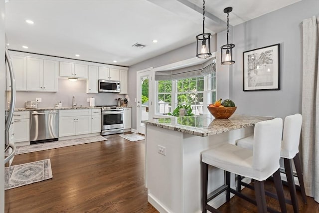48 W Park Dr, Wakefield, MA 01880 - kitchen featuring stainless steel appliances, white cabinetry, light stone counters, dark wood-style flooring, and a sink