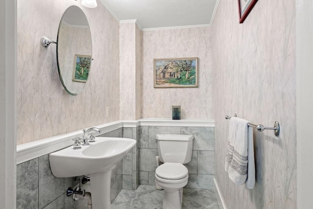 half bath featuring wallpapered walls, toilet, and ornamental molding