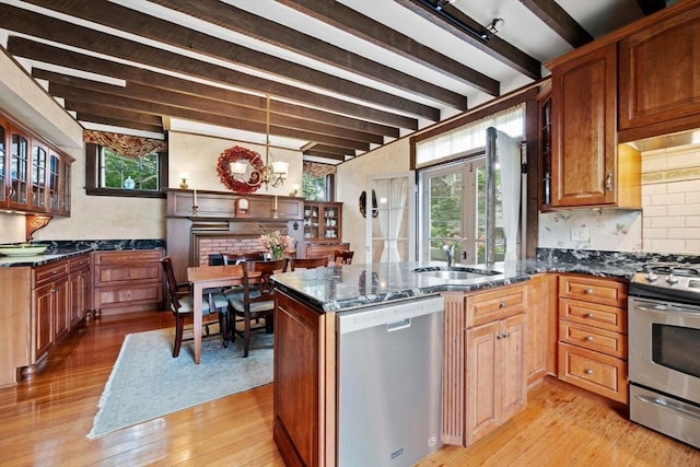 kitchen featuring a sink, beamed ceiling, light wood-style floors, and stainless steel appliances