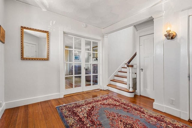 entryway with stairs, baseboards, and hardwood / wood-style floors