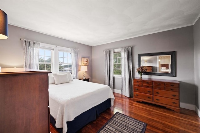 bedroom with baseboards and dark wood-type flooring