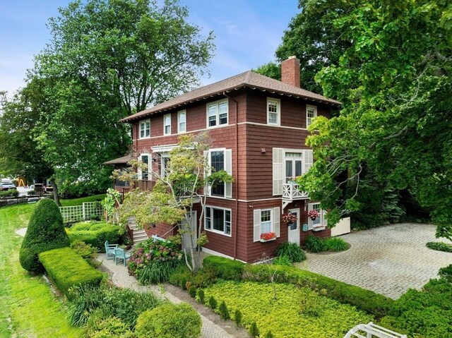 view of side of property with stairs, a patio, and a chimney