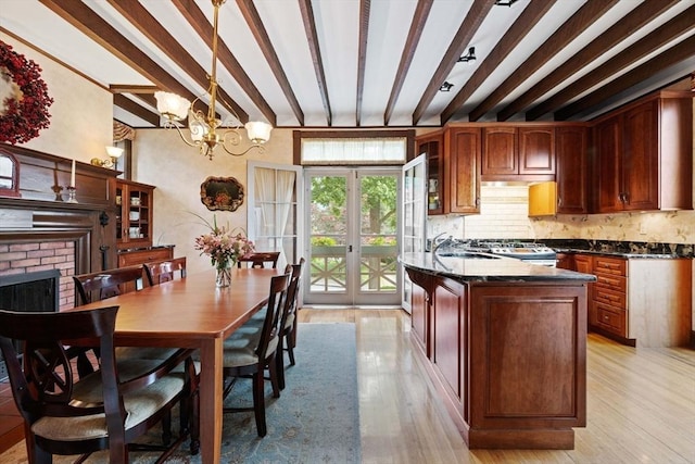 kitchen featuring a sink, beam ceiling, tasteful backsplash, and light wood-style flooring