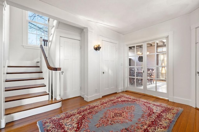 entrance foyer featuring stairway, french doors, baseboards, and wood-type flooring