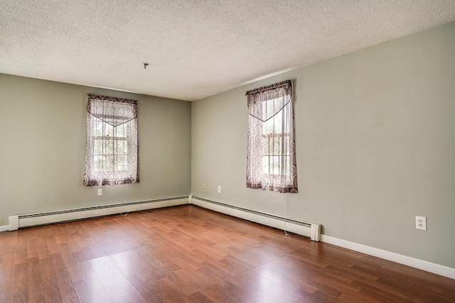 39 Lantern Ln Unit 7, Dracut, MA 01826 - empty room with wood finished floors, baseboard heating, a textured ceiling, and baseboards