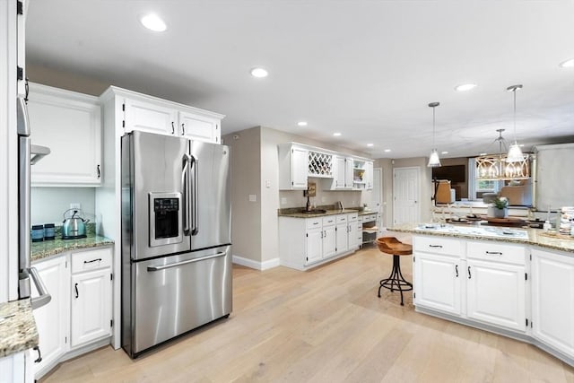 1 Preston Cir, Andover, MA 01810 - kitchen featuring stainless steel fridge, light wood-style floors, white cabinets, a kitchen bar, and recessed lighting