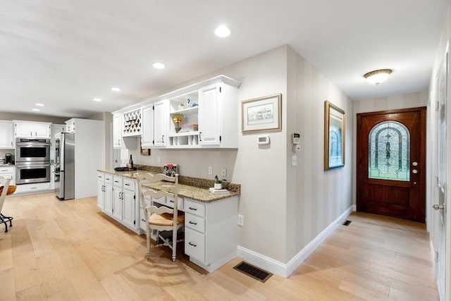 1 Preston Cir, Andover, MA 01810 - kitchen featuring appliances with stainless steel finishes, light wood finished floors, light stone countertops, white cabinetry, and recessed lighting