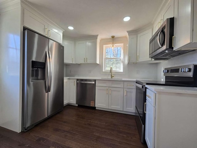 kitchen with stainless steel appliances, sink, pendant lighting, and white cabinets