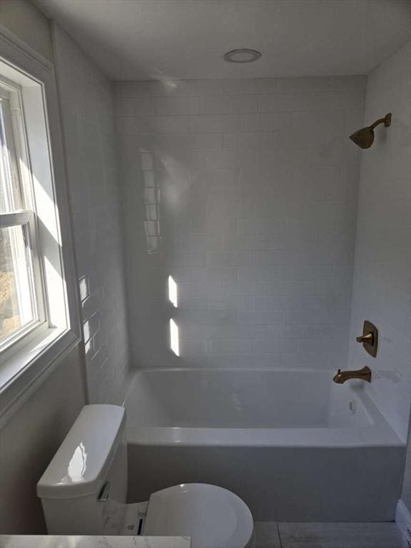 bathroom with tiled shower / bath and toilet