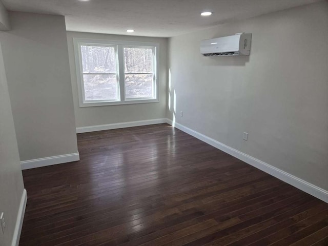 empty room with dark hardwood / wood-style floors and a wall unit AC