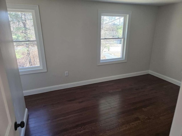 spare room with dark hardwood / wood-style floors and a wealth of natural light