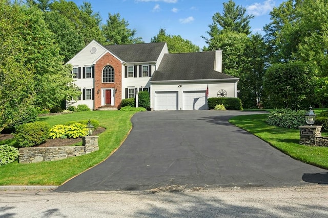 75 Kennedy Cir, Northbridge, MA 01534 - colonial-style house featuring a chimney, driveway, an attached garage, a front yard, and brick siding